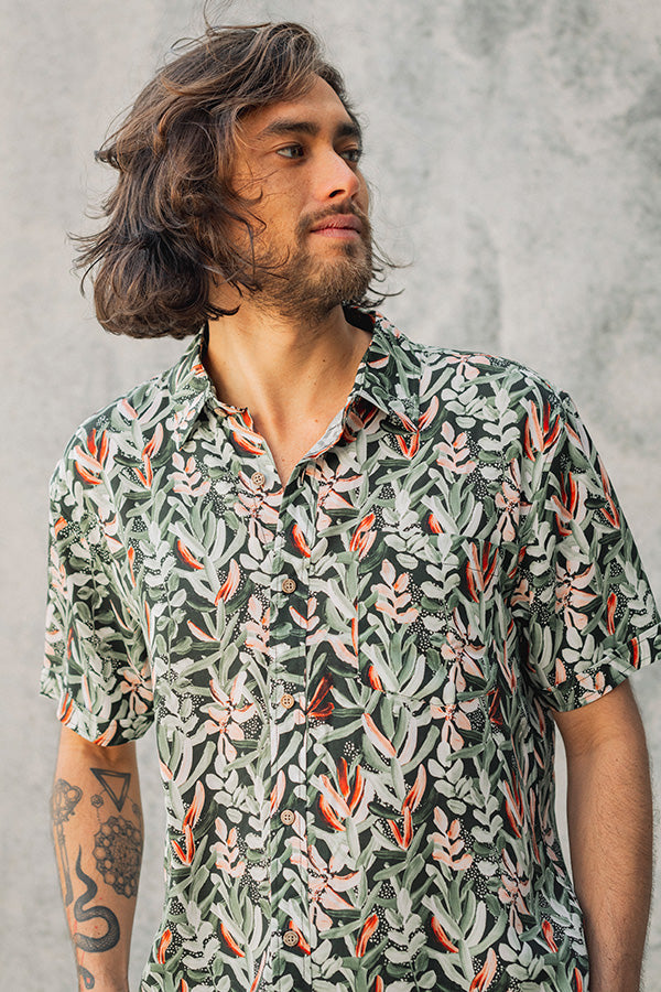 Men's short sleeve shirt featuring a Protea print on a green background