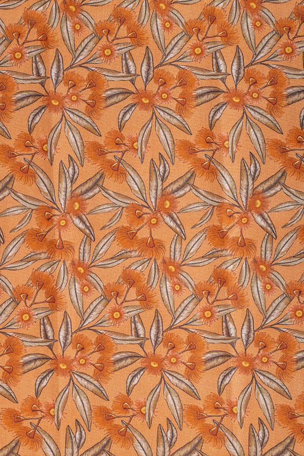 Delicate terracotta print featuring flowering gum blossoms and foliage in shades of red and green, capturing the vibrant essence of the Australian landscape