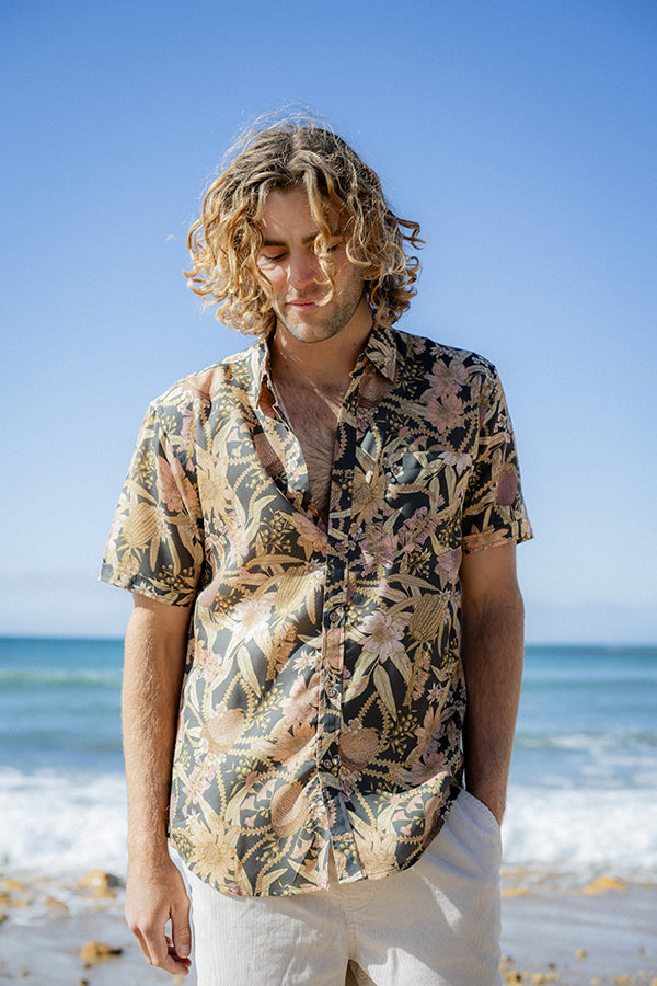Men's short sleeve shirt featuring an Australian native floral print with banksia and waratah motifs on a dark base