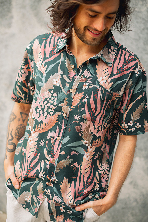 Men's short sleeve shirt with vibrant hand-painted blooms on a teal base