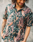 Men's short sleeve shirt with vibrant hand-painted blooms on a teal base