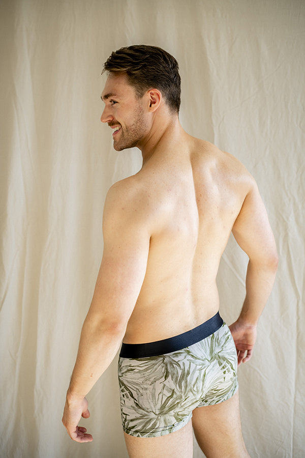 Eco-friendly boxer briefs featuring detailed fan palm designs on a sage background