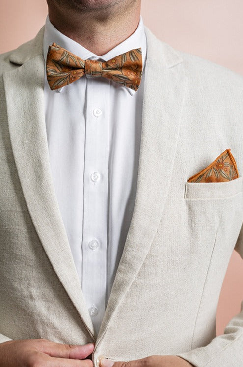 Elegant pocket square showcasing a terracotta-colored flowering gum print, with detailed blossoms in shades of red and green, offering a warm, earthy accent to formal attire