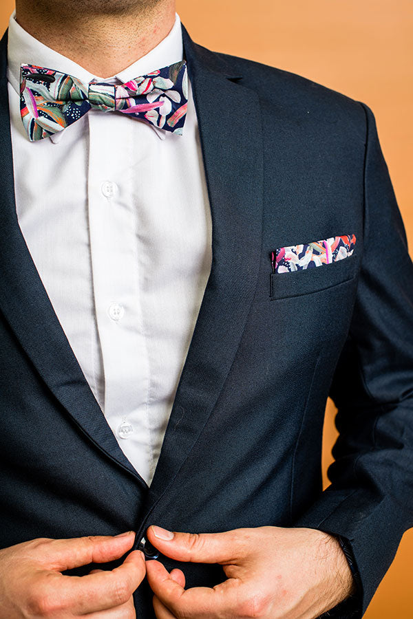 Modern and stylish bow tie featuring a detailed protea print in navy, complemented by shades of pink and green, reflecting the deep, rich tones of this flower