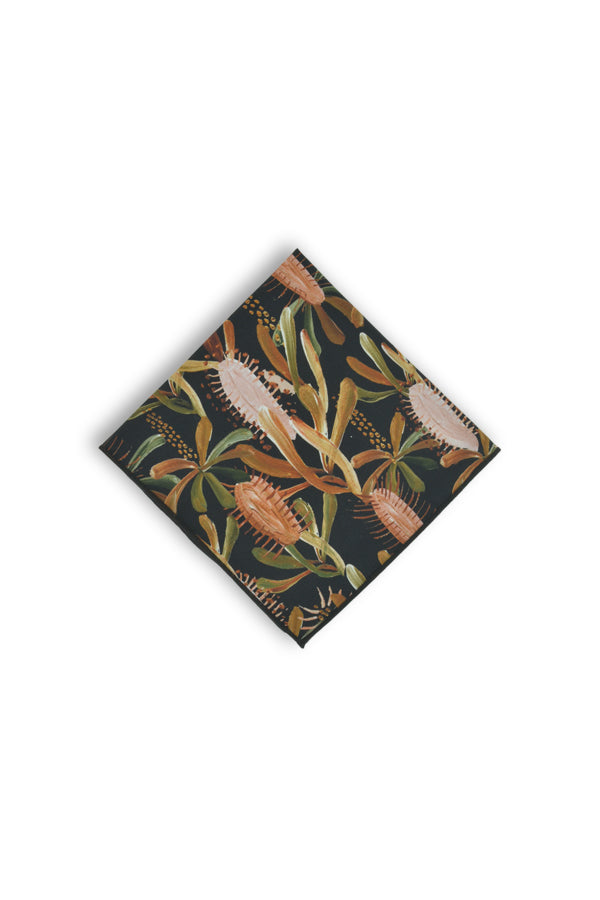 Sophisticated black pocket square adorned with delicate patterns of burnt orange, sage green, terracotta, and light pink grass tree leaves, perfect for adding a touch of nature to formal wear